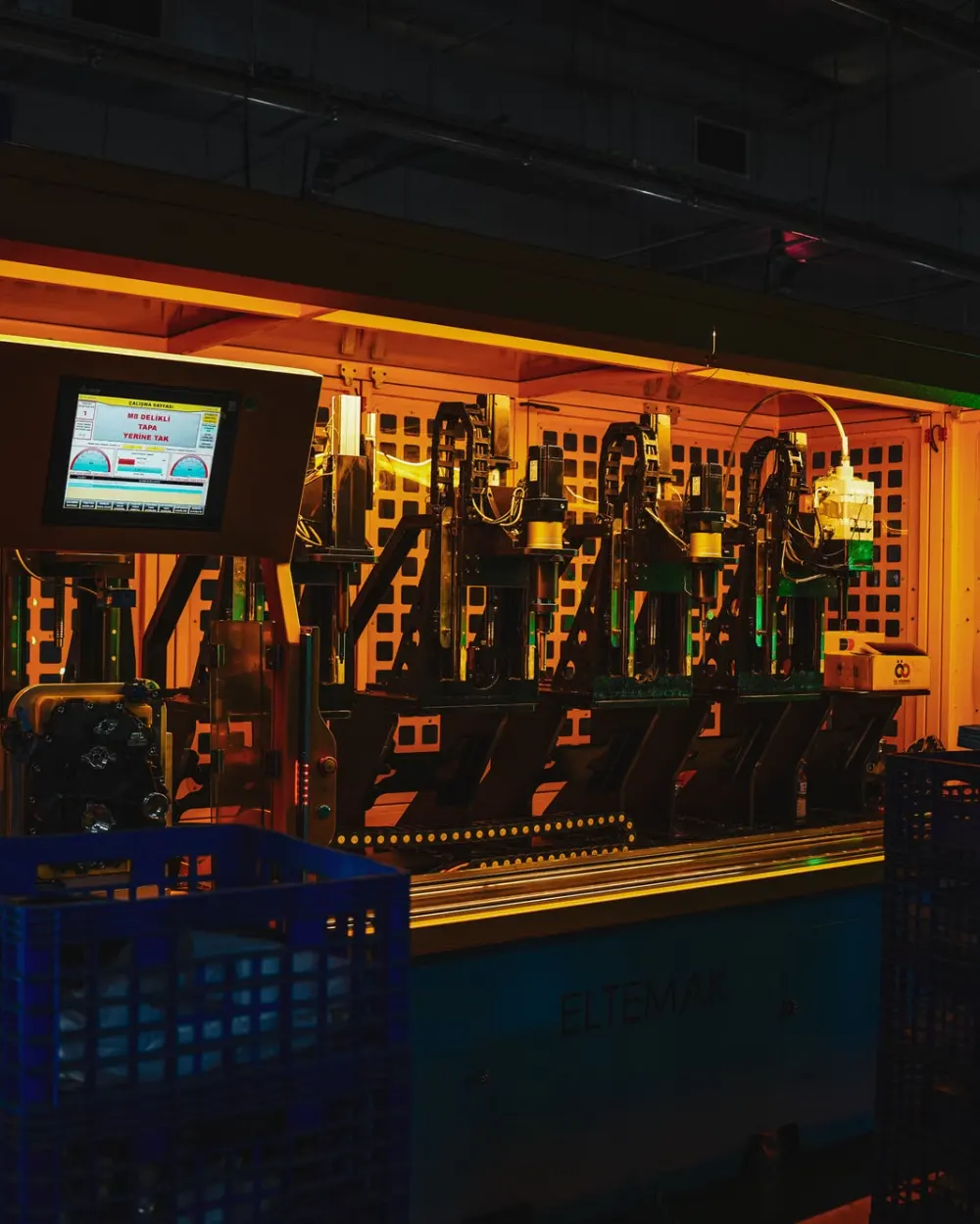 Automated production line lit in amber in a dark factory hall